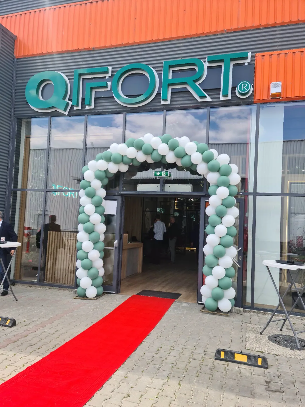 Arcada din baloane verzi si albe cu covor rosu la inaugurarea unui showroom QFORT