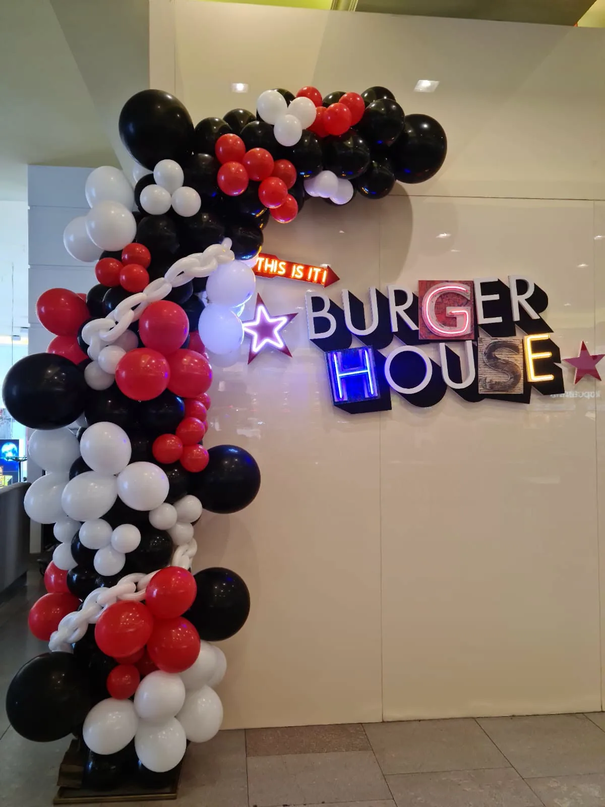 Arcada organica din baloane rosii, negre si albe la un restaurant Burger House