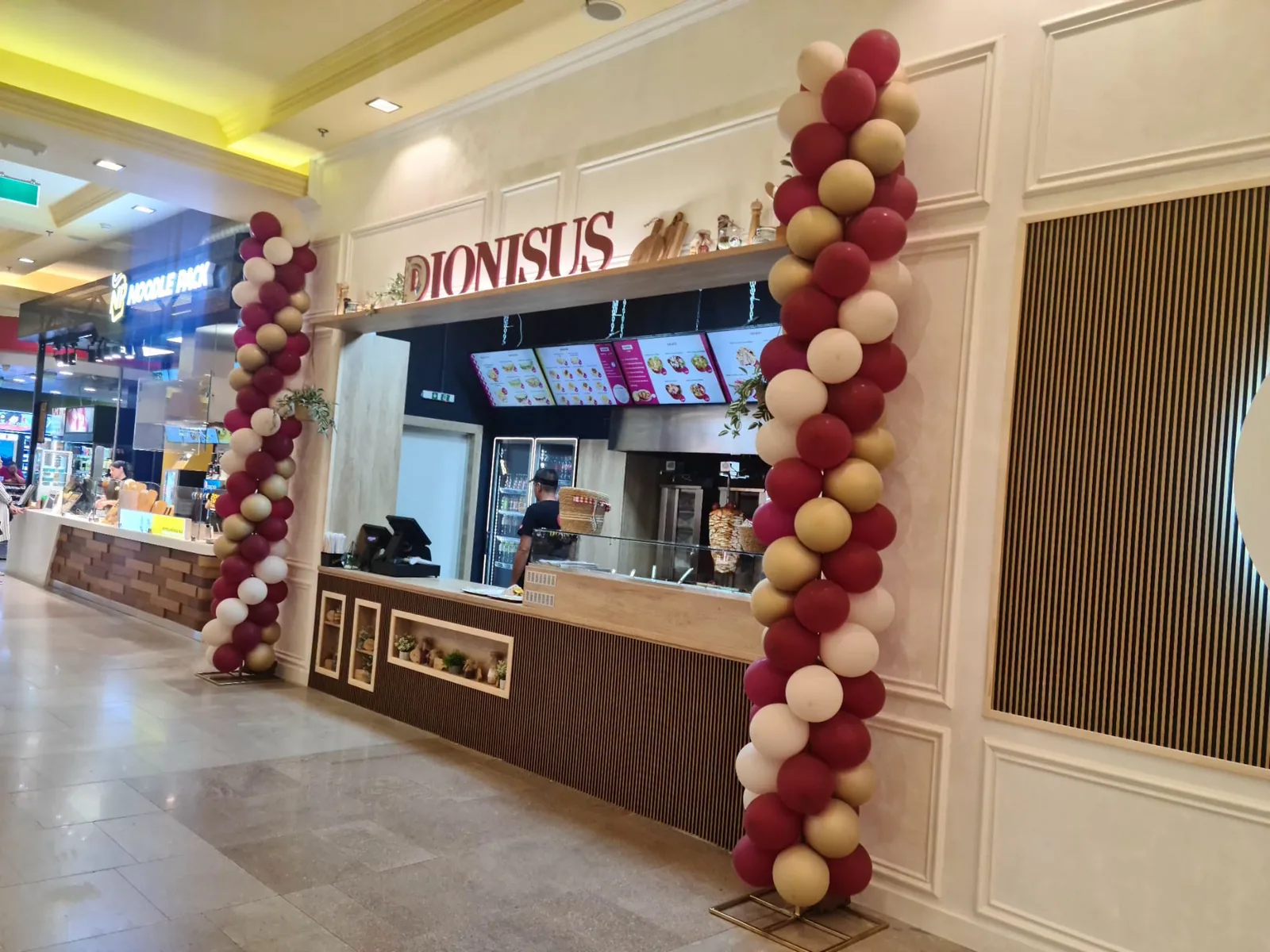 Coloane de baloane bordo si crem la un punct gastronomic Dionisus din mall