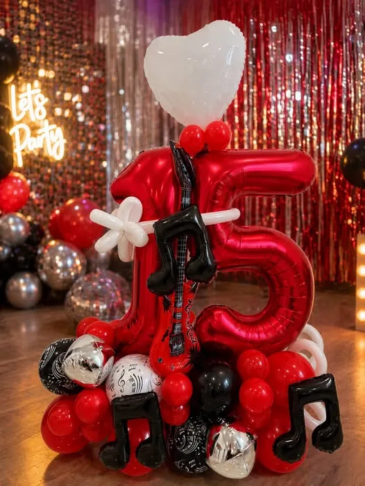 Decor de aniversare cu tematică muzicală, baloane roșii și negre și cifra 15