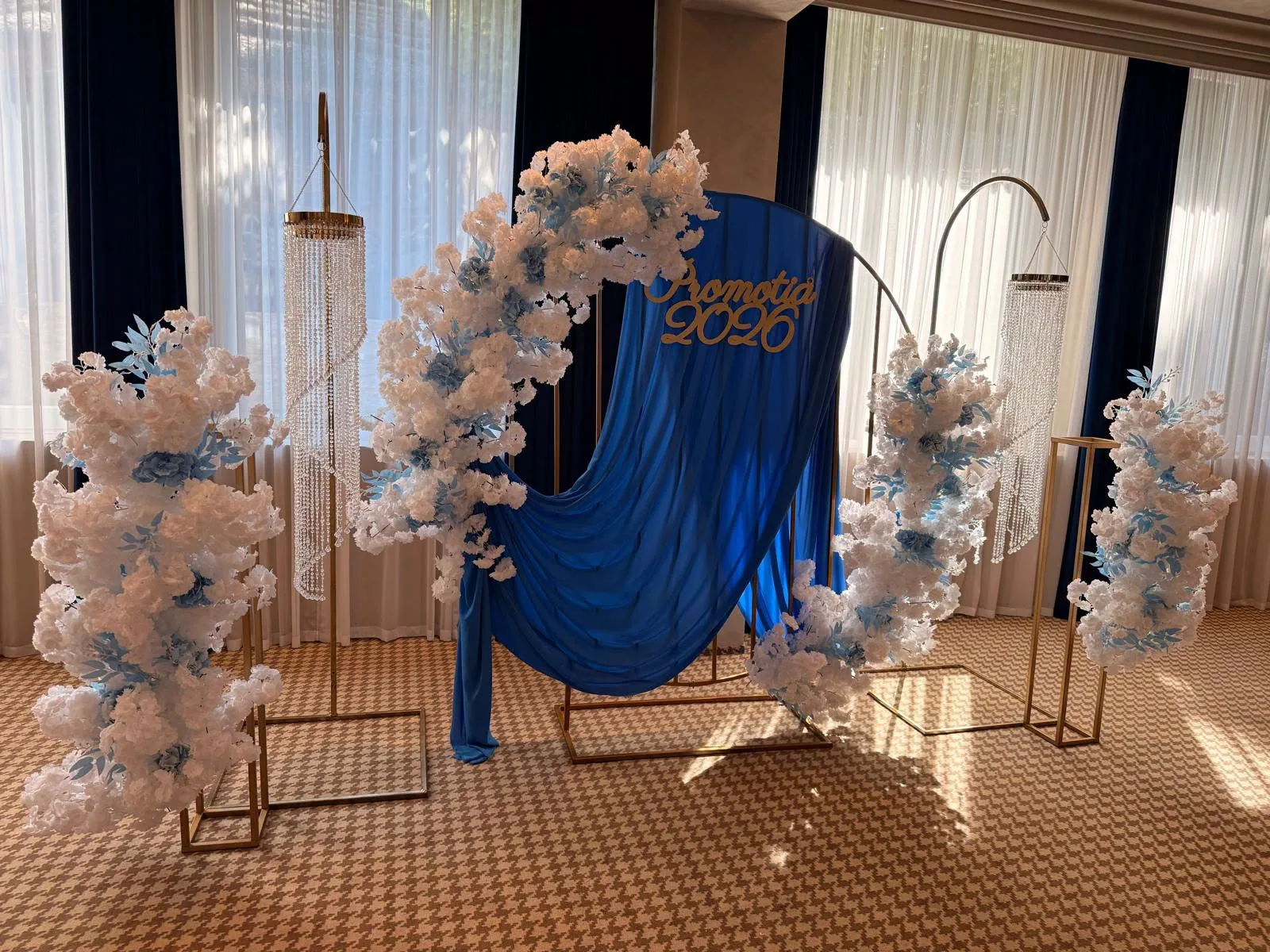 Decor de banchet de absolvire cu panou „Promoția 2026”, drapaj albastru și aranjamente florale albe