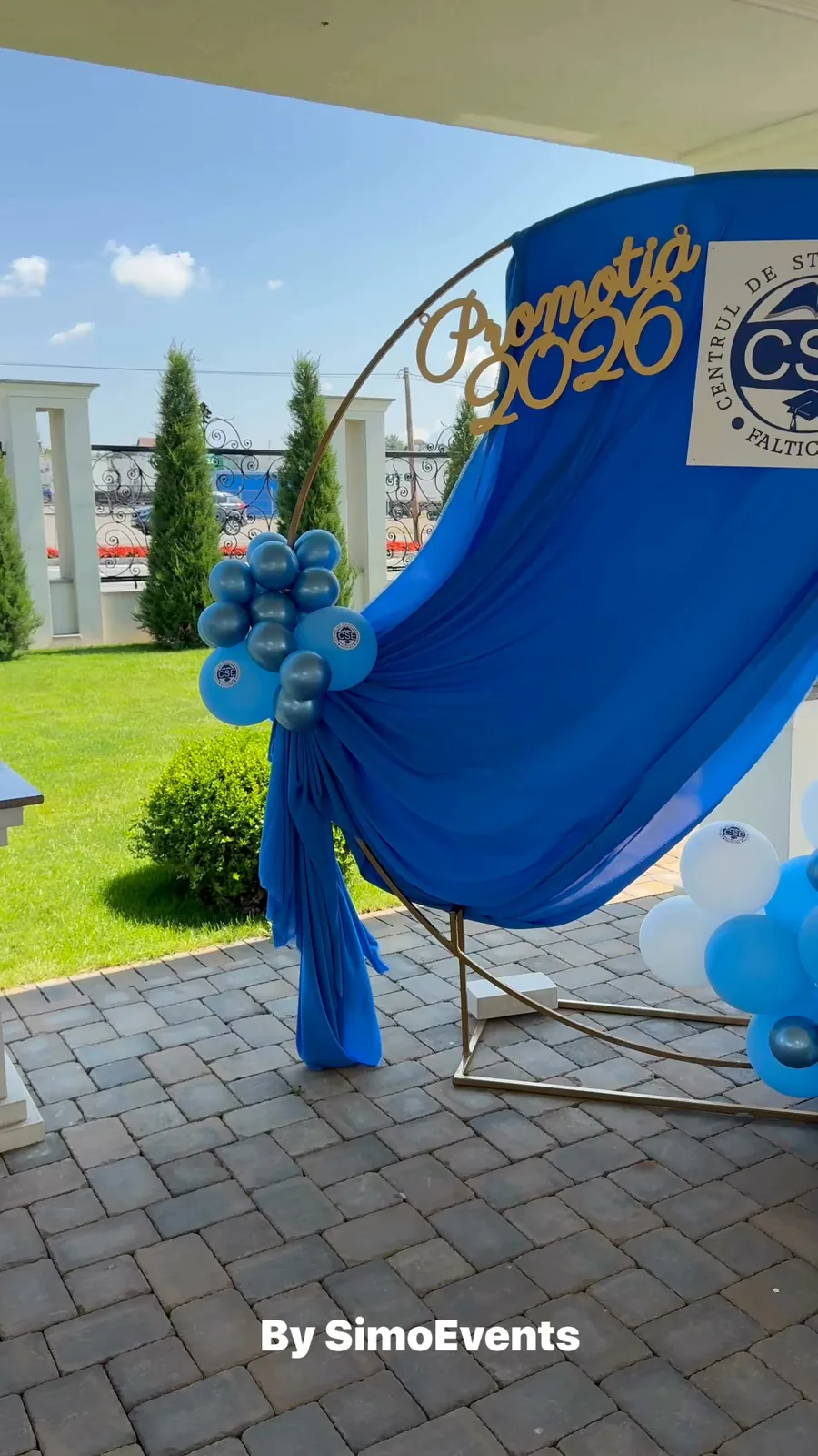 Panou rotund cu drapaj albastru și inscripția „Promoția 2026”, cu baloane asortate