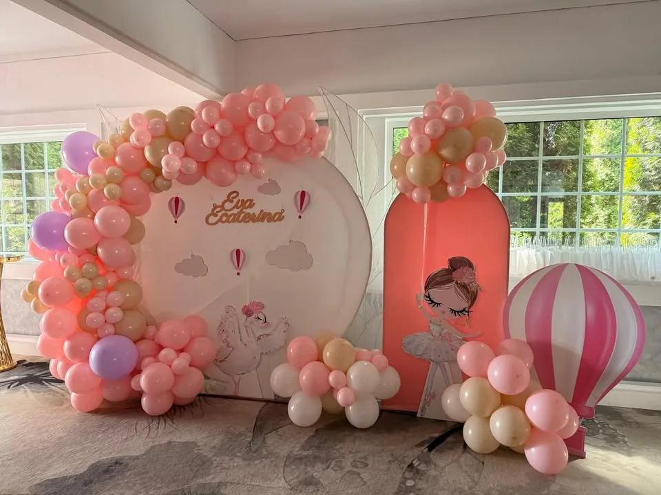 Photocorner de botez în nuanțe de roz, cu balon aerostat, lebădă și fluturi luminoși