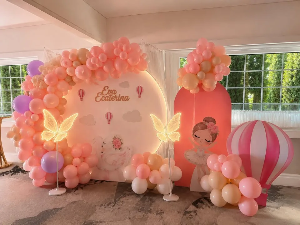 Photocorner de botez roz, cu fluturi luminoși aprinși și baloane pastelate