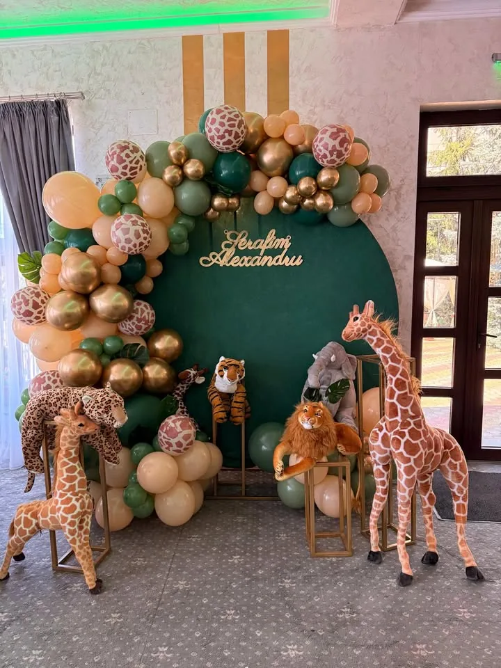 Photocorner de botez cu temă safari, panou verde, girafe și animale de pluș