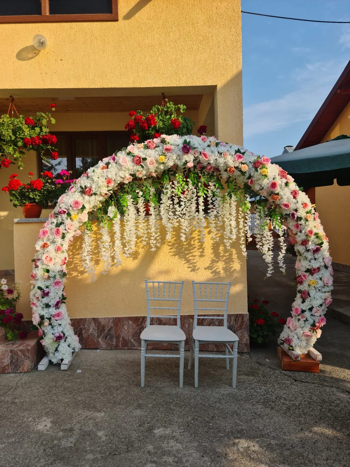 Arcadă florală rotundă cu glicină albă și două scaune Chiavari albe