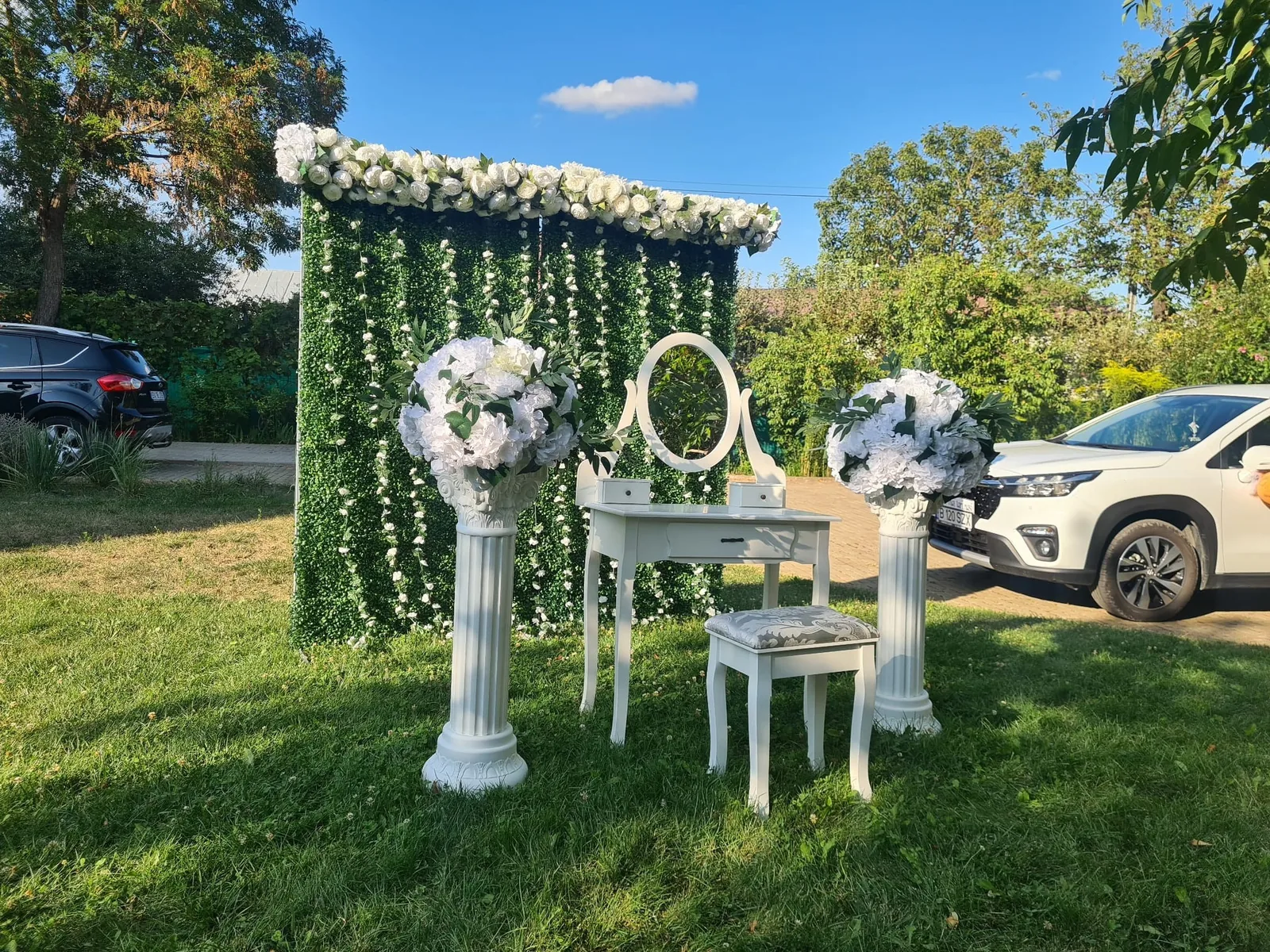 Decor gătitul miresei în grădină: arcadă florală albă, măsuță și scaun alb