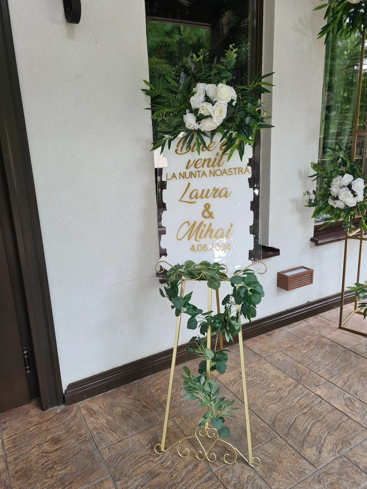 Șevalet de nuntă cu placă de plexiglas albă și decor floral, la intrare
