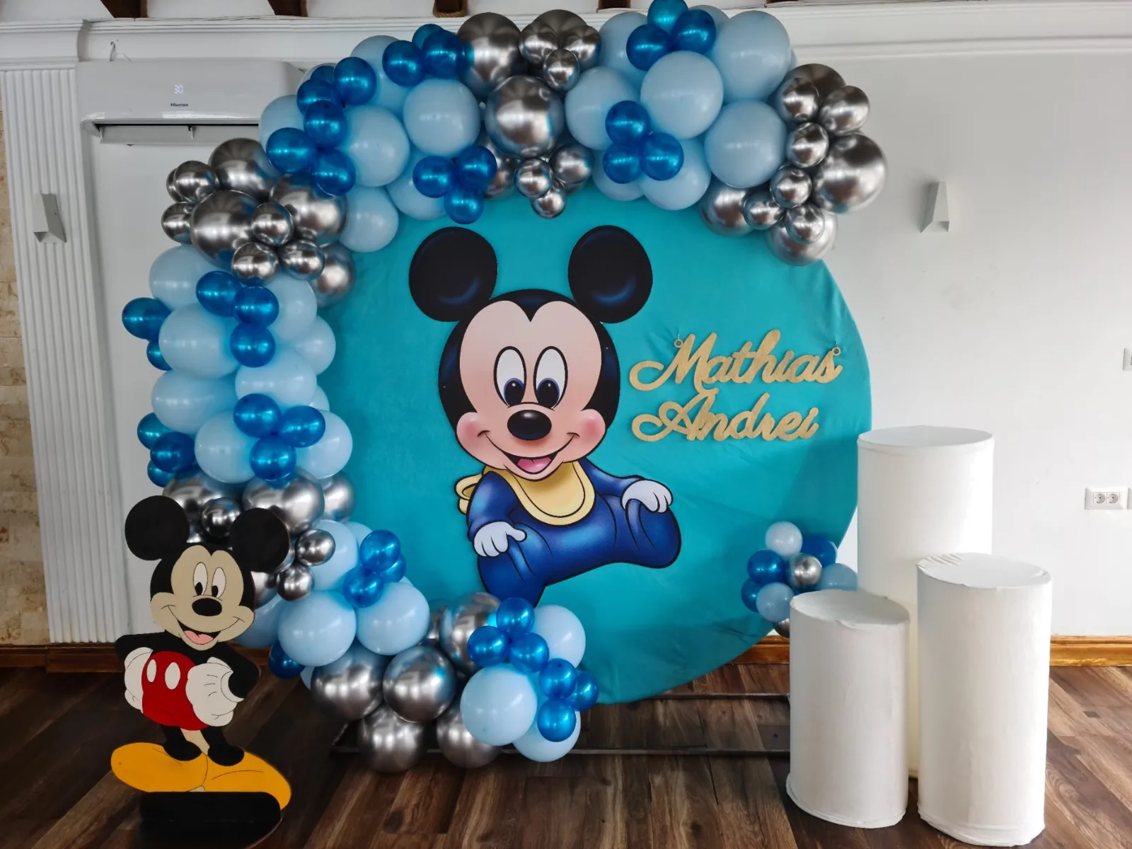 Photocorner de botez turcoaz cu argintiu, personaj Mickey Mouse baby, coloane albe, panoul cu numele Mathias Andrei