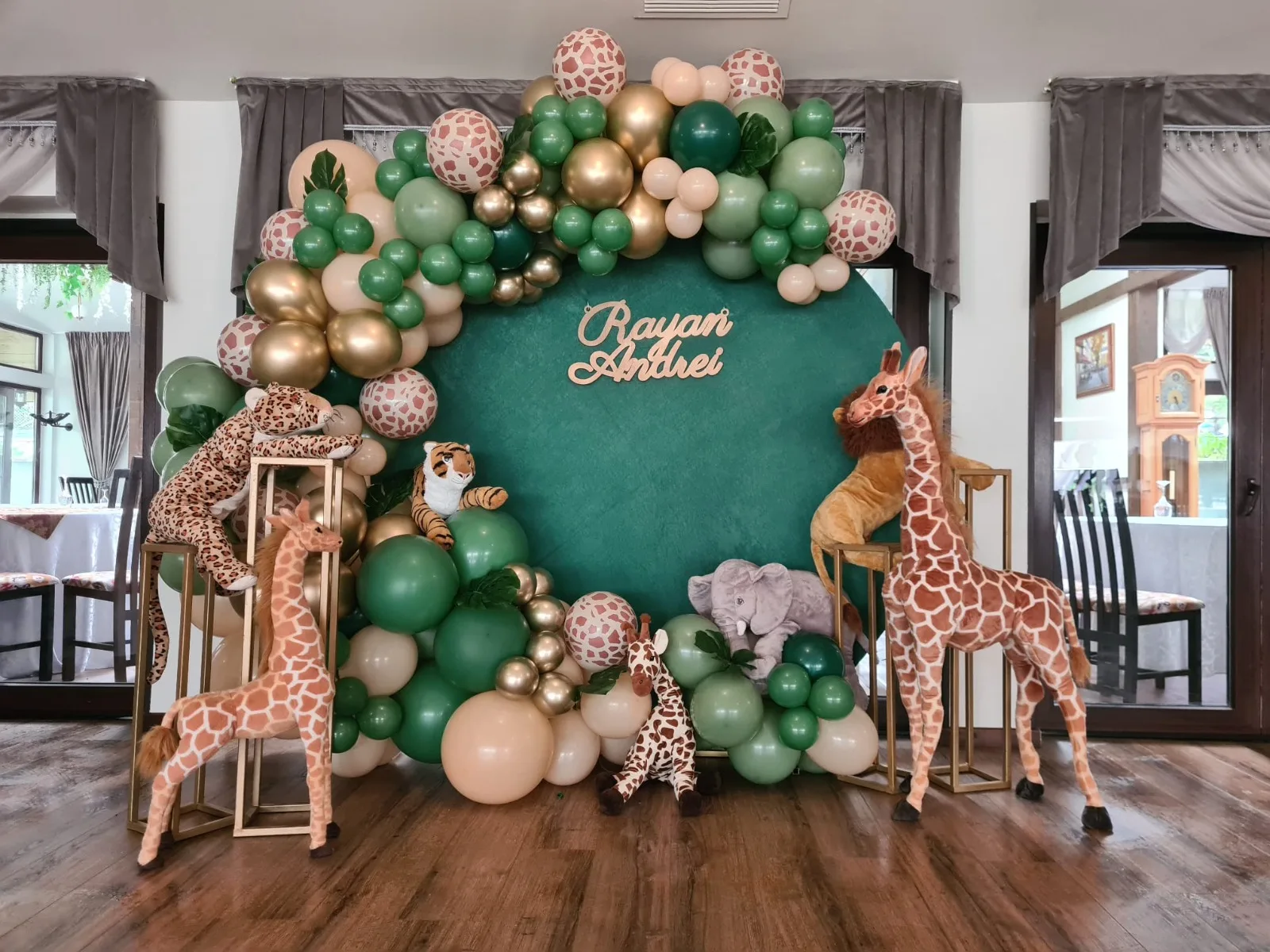 Photocorner de botez tematic jungle/safari cu girafe, tigru și leu de pluș, panoul cu numele Rayan Andrei