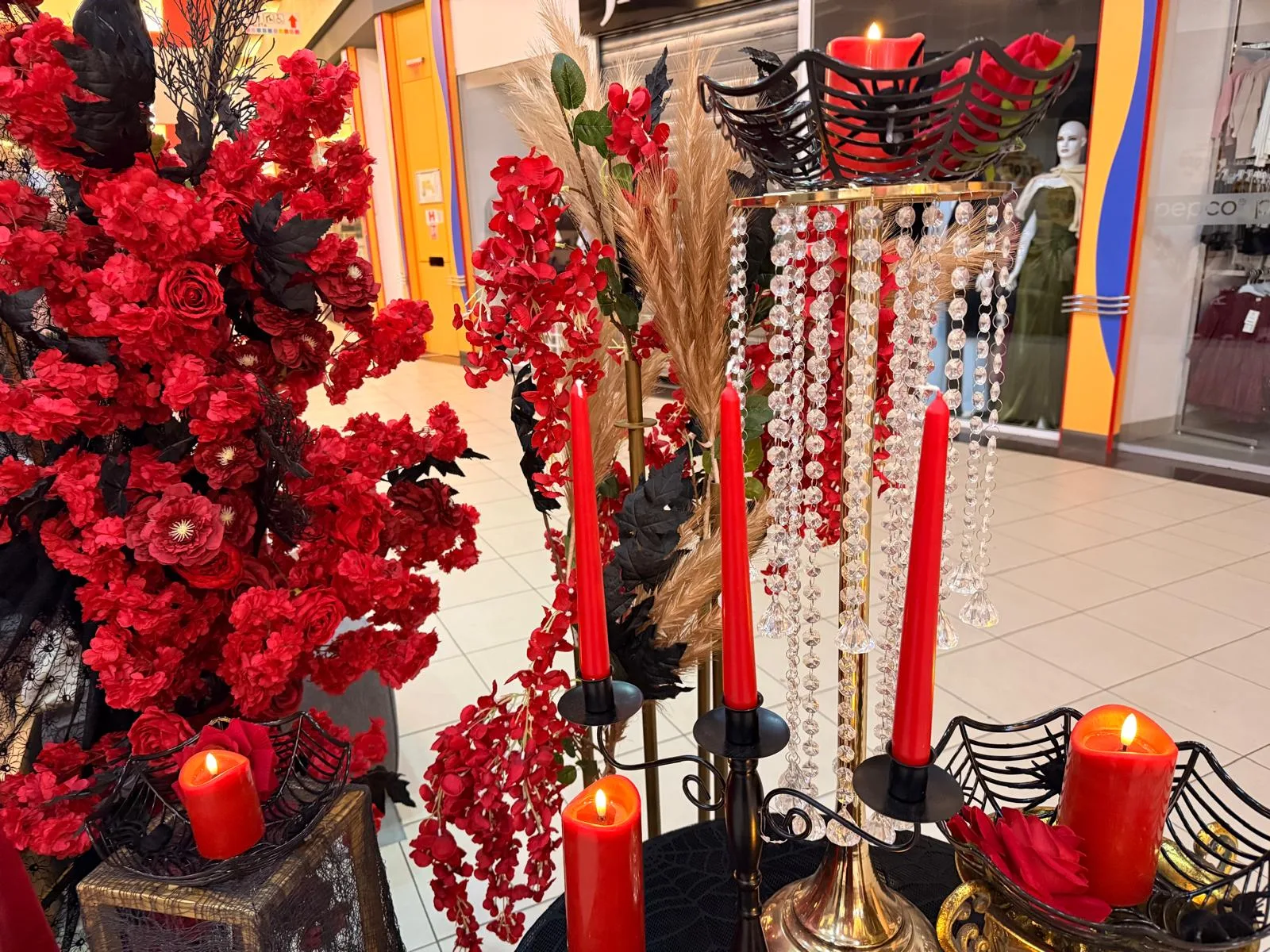 Aranjament cu flori rosii, lumanari si cristale pe suport auriu, decor corporate Halloween in mall