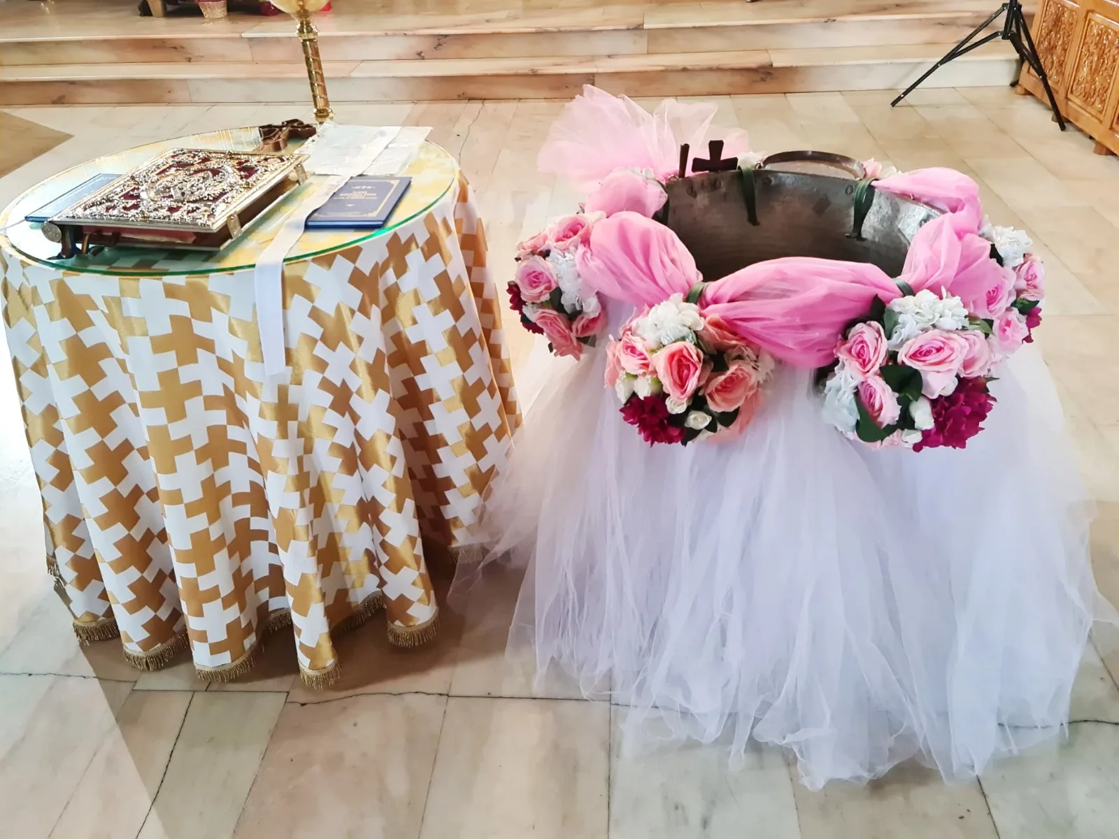 Decor de cristelniță în biserică, cu coronițe de trandafiri roz și albi și tul alb