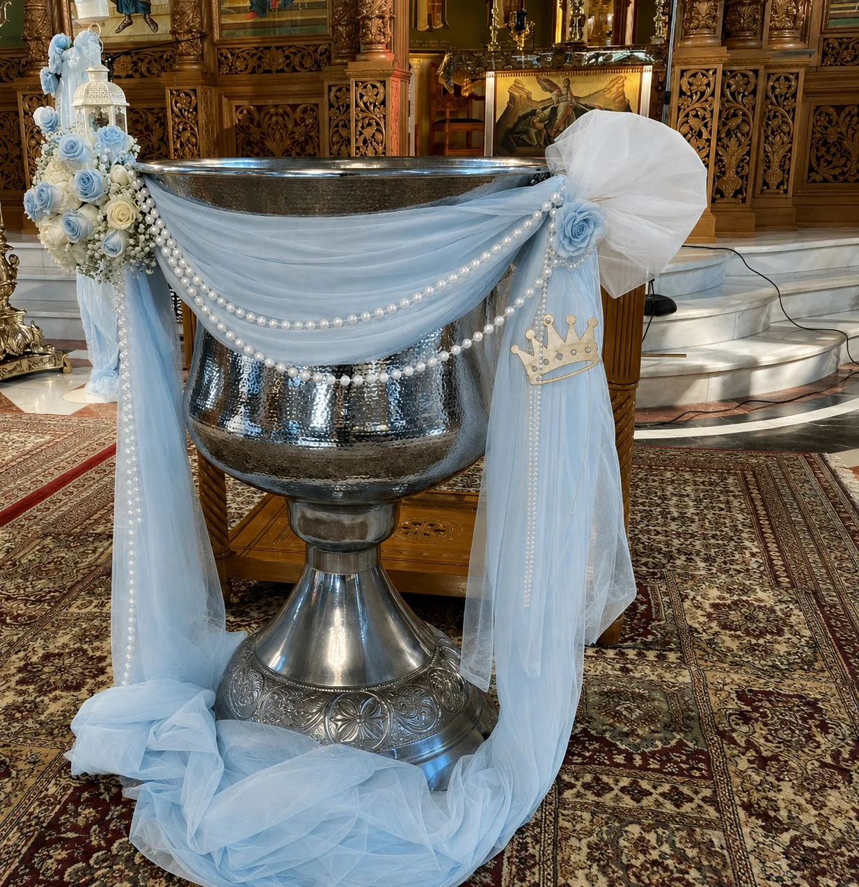 Decor de cristelniță în biserică, cu tul verde pastel, lanț de perle, coroniță aurie și flori albe