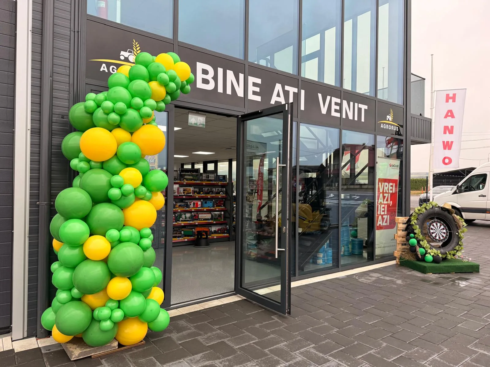 Arcadă din baloane verzi și galbene la intrarea magazinului Agrorus, cu mesajul Bine ați venit