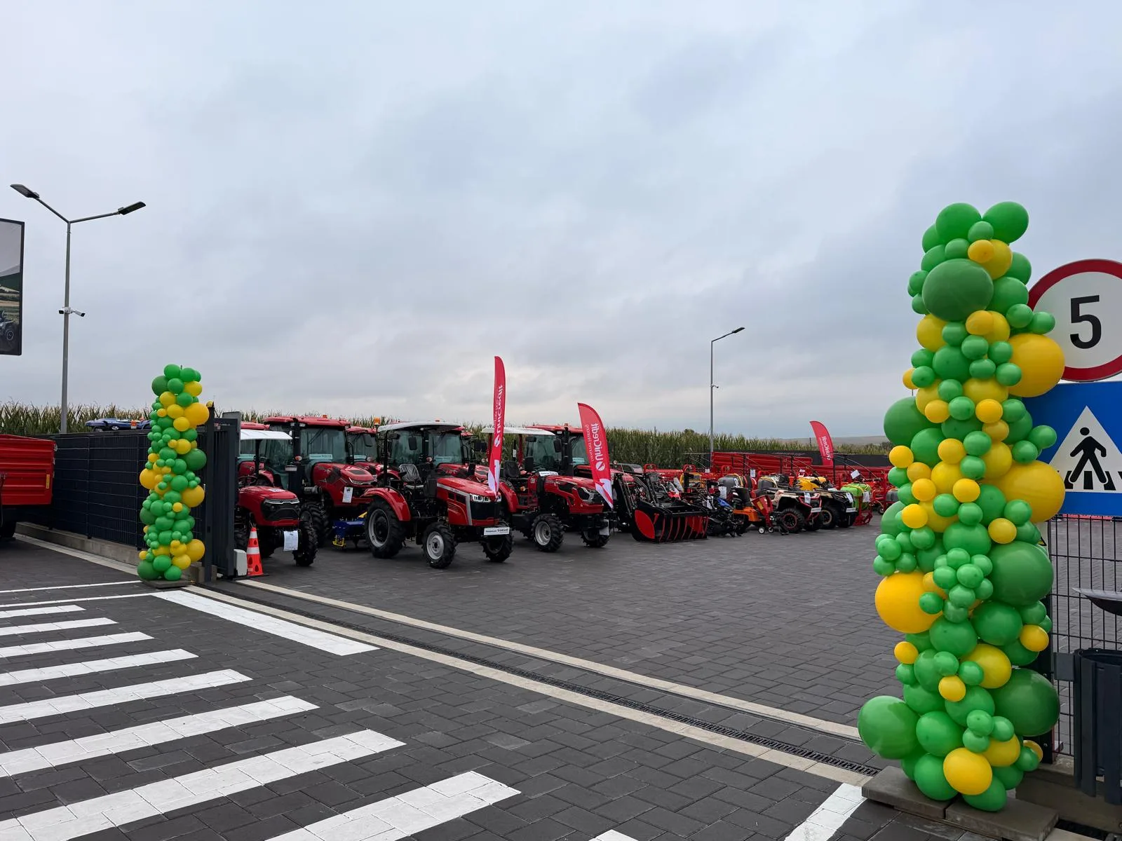 Coloane din baloane verzi și galbene la intrarea unei expoziții cu tractoare