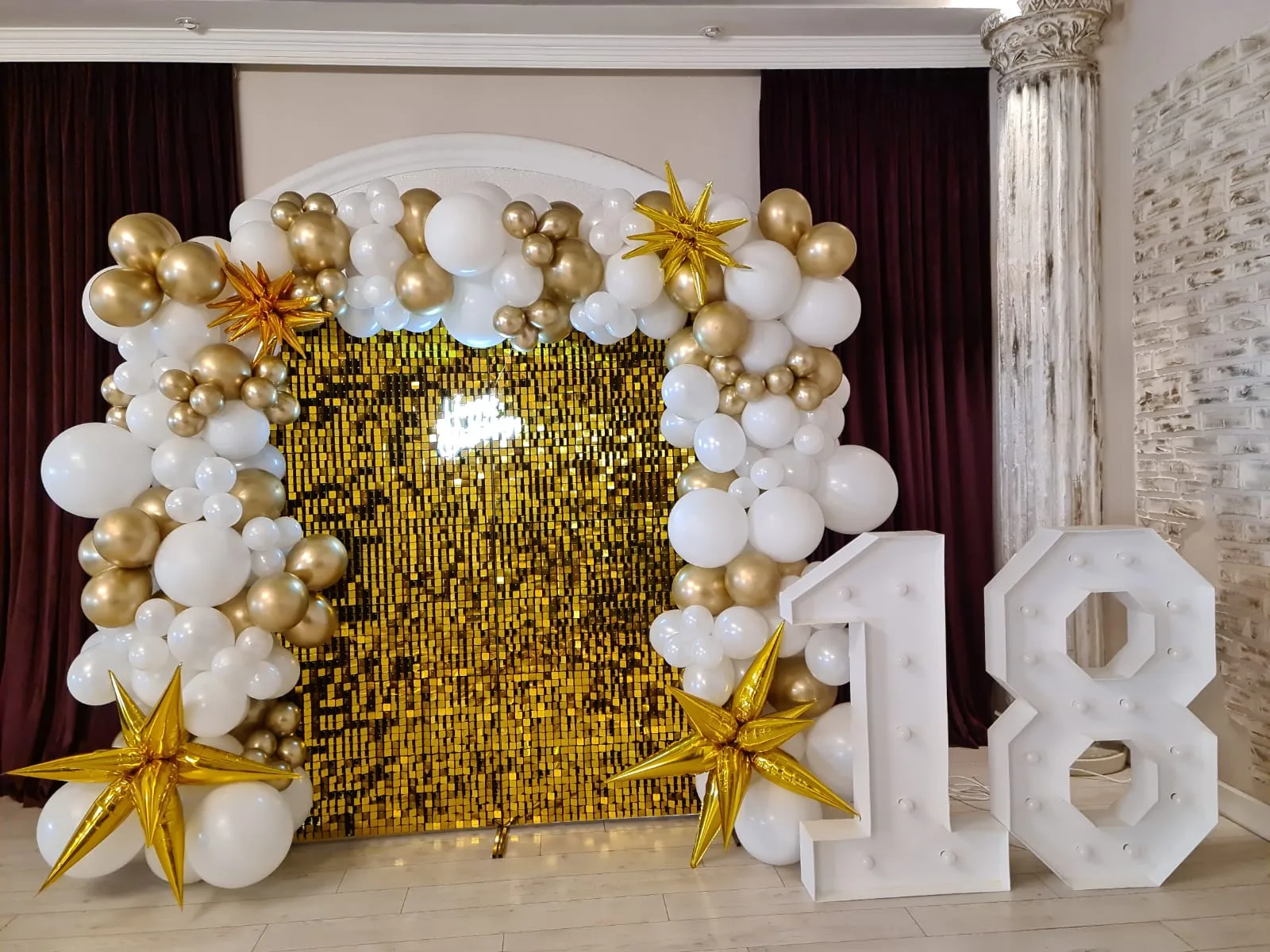 Decor majorat 18 ani cu arcada de baloane alb-auriu, perete sclipici auriu si cifre luminoase 1 si 8