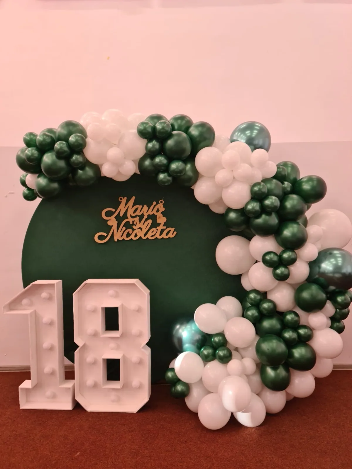 Decor majorat 18 ani, fundal verde cu arcada de baloane verde si alb, cifra 18 luminoasa