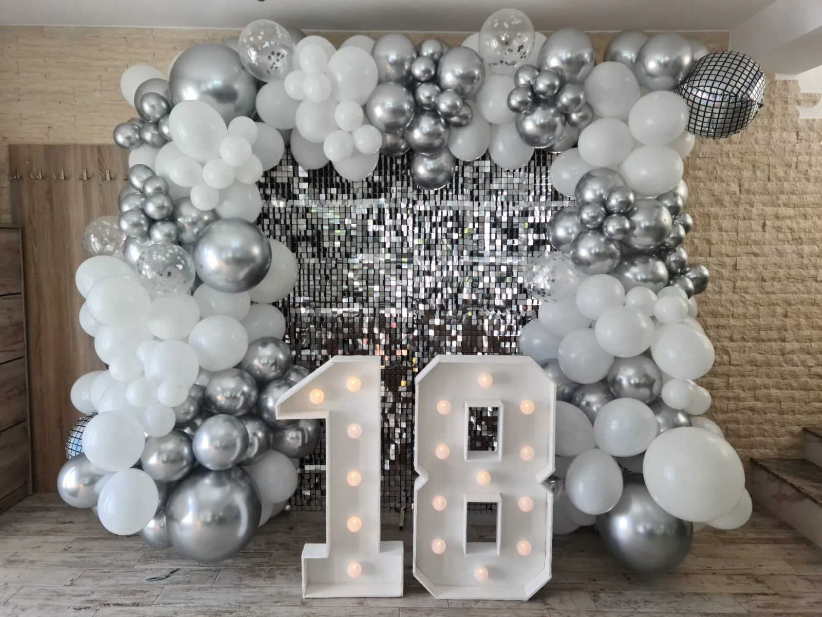 Decor majorat 18 ani, fundal cu paiete argintii, baloane albe si glob disco