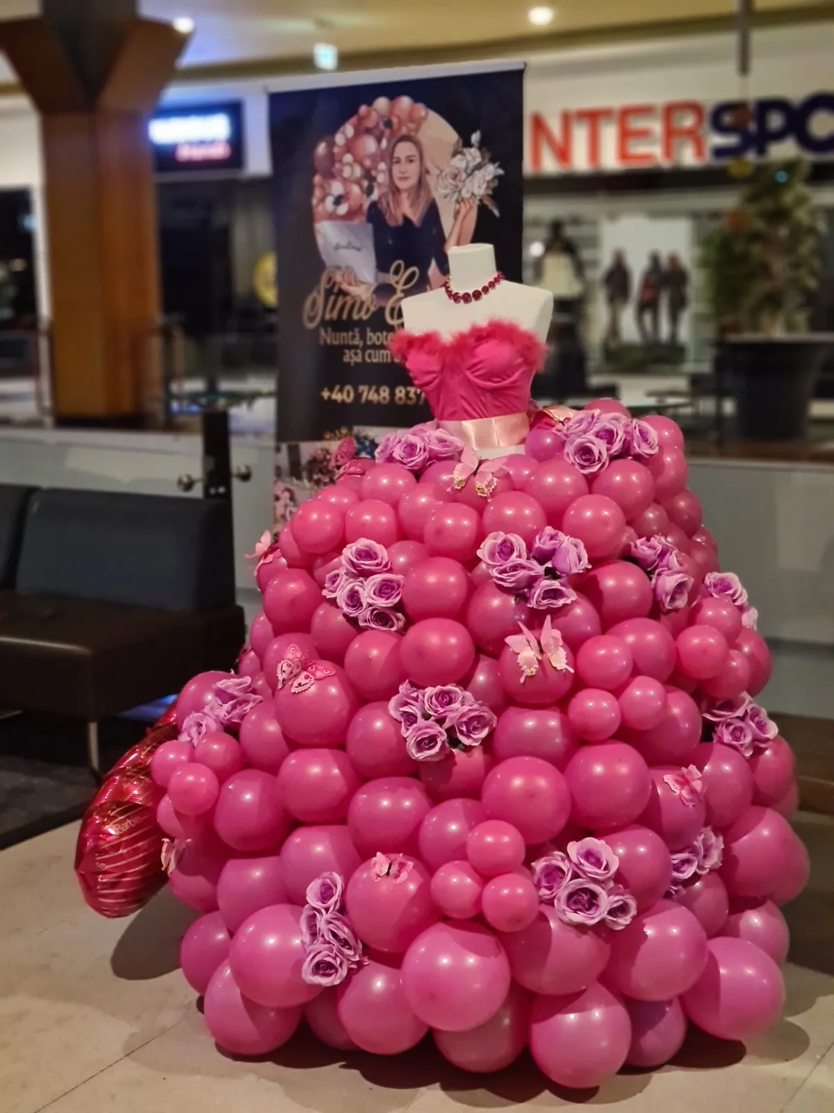 Rochie din baloane roz fucsia cu trandafiri mov și fluturi, pe manechin cu corset roz