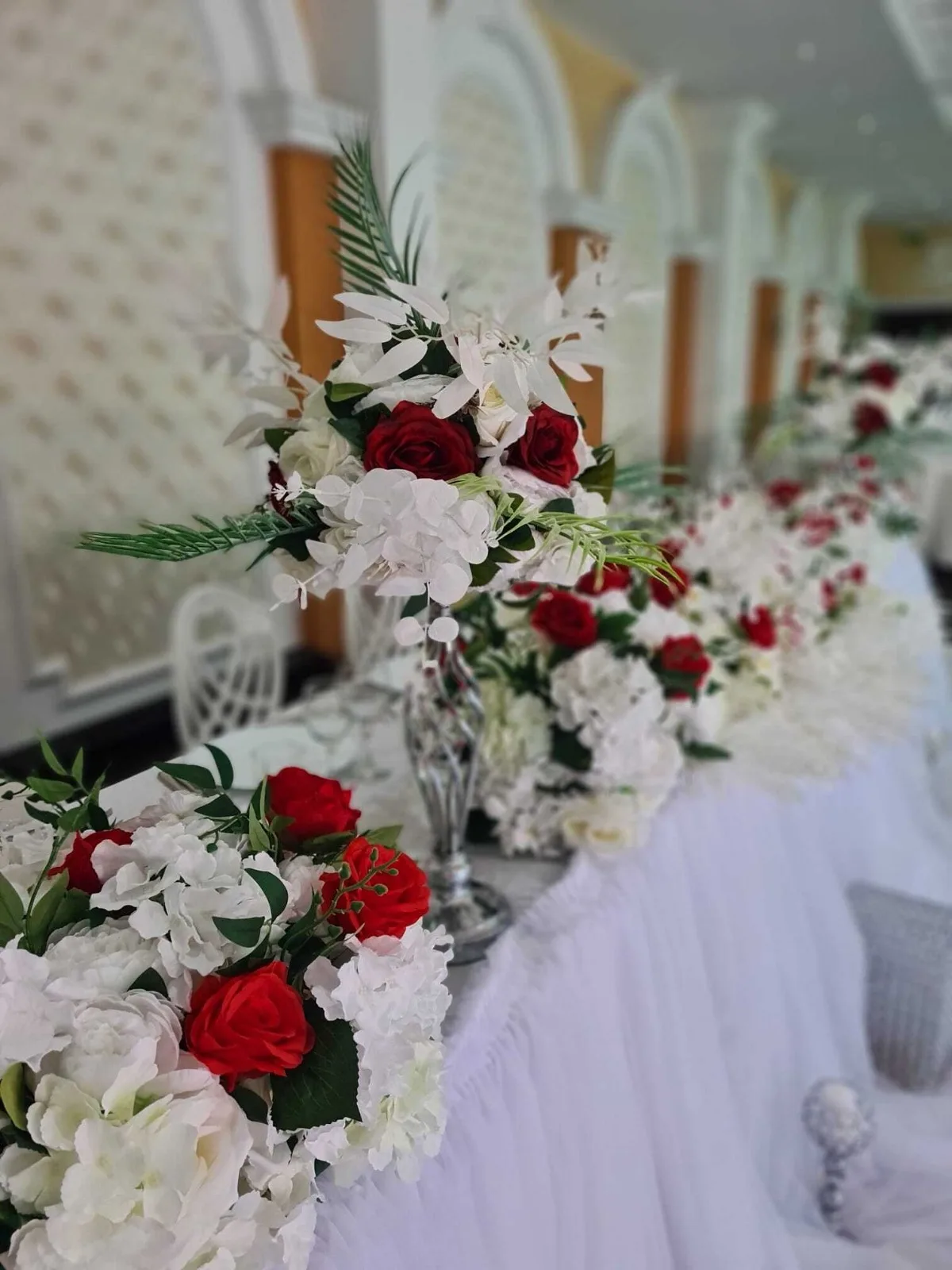 Detaliu de aproape al prezidiului cu trandafiri roșii și flori albe, Sala Zamca