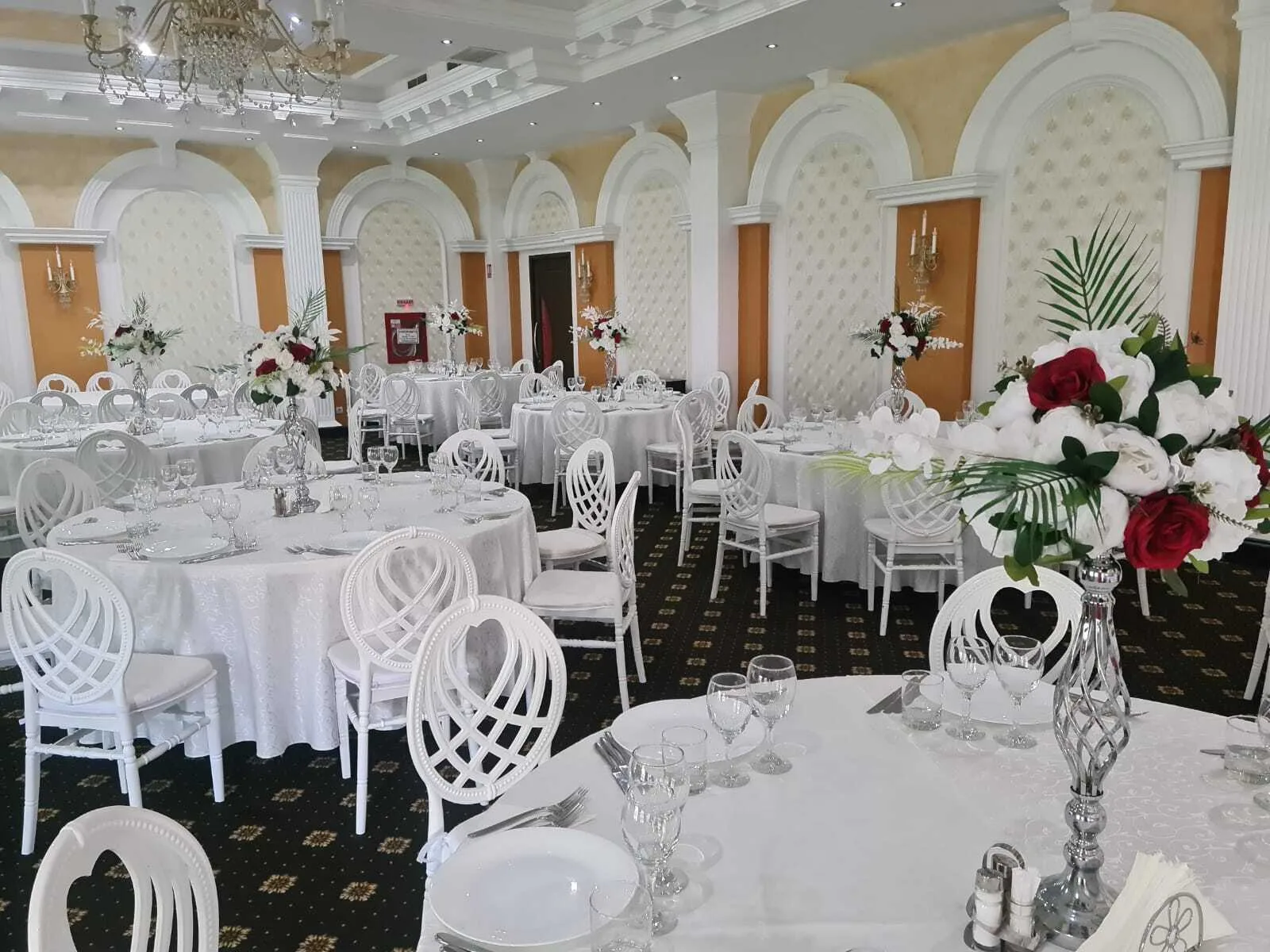 Sala Zamca amenajată cu mese rotunde albe și scaune decorative