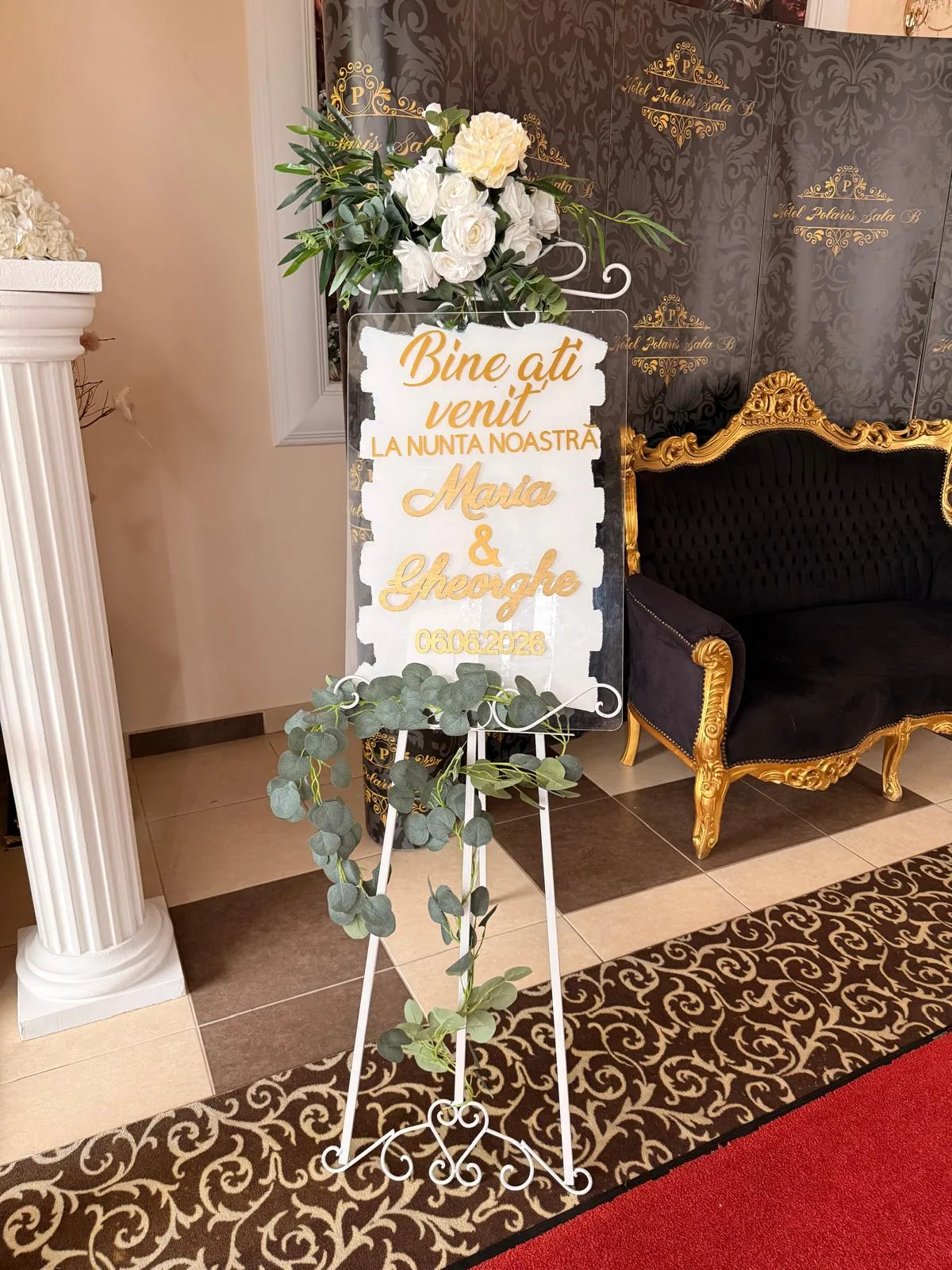 Șevalet alb cu panou Bine ați venit la nuntă, decorat cu flori albe și verdeață