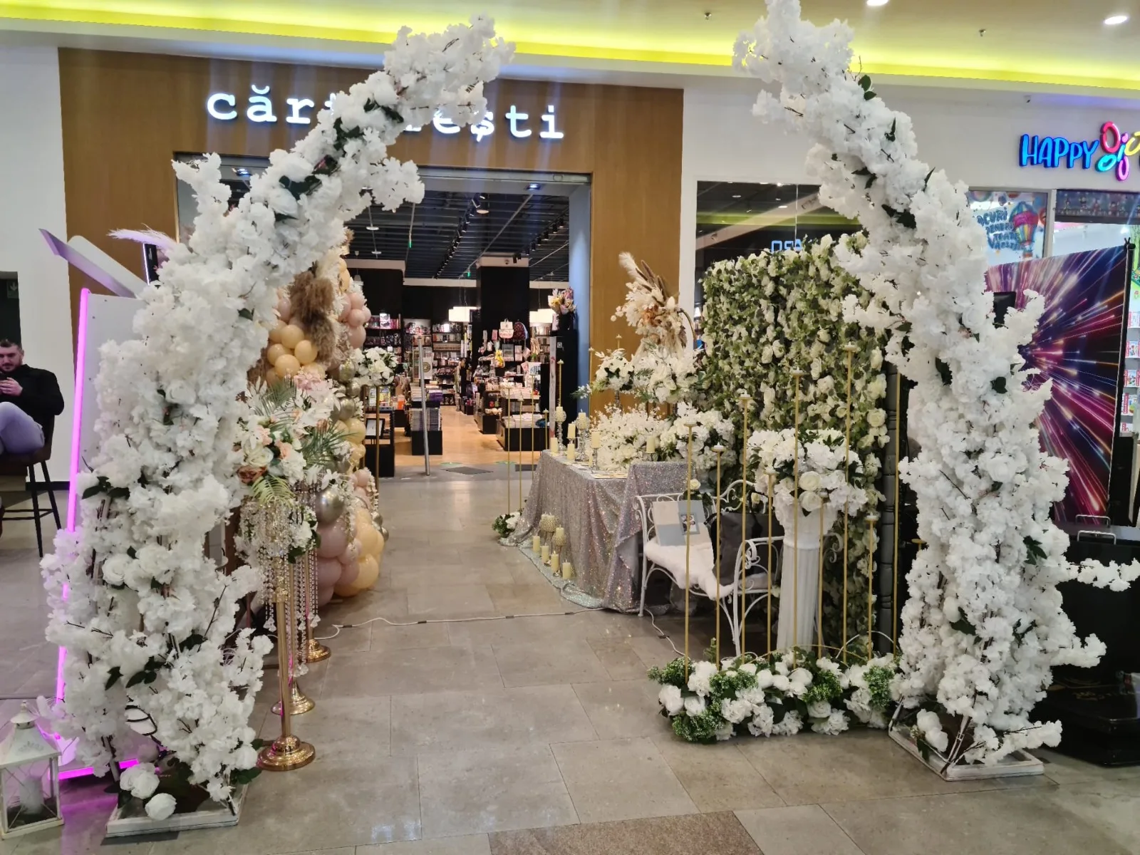 Arcada florala alba cu baloane roz la intrarea standului SimoEvents