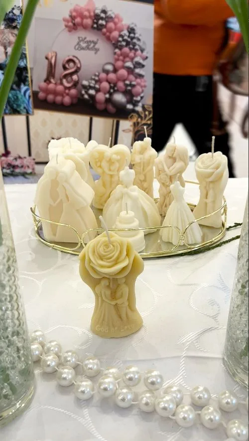 Lumânări decorative mire și mireasă, trandafiri albi și perle la standul de la târgul de nunți