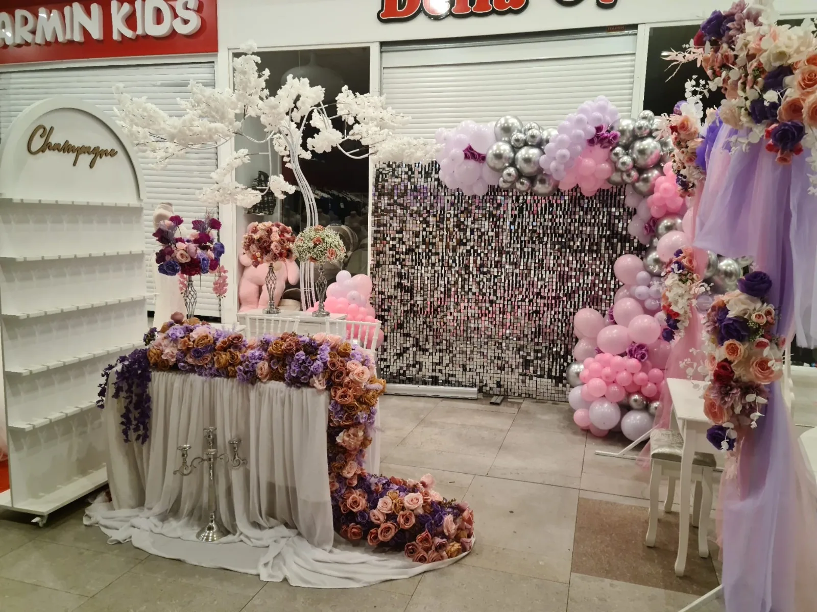 Stand SimoEvents la targul de nunti, cu perete de paiete argintii, baloane roz si flori