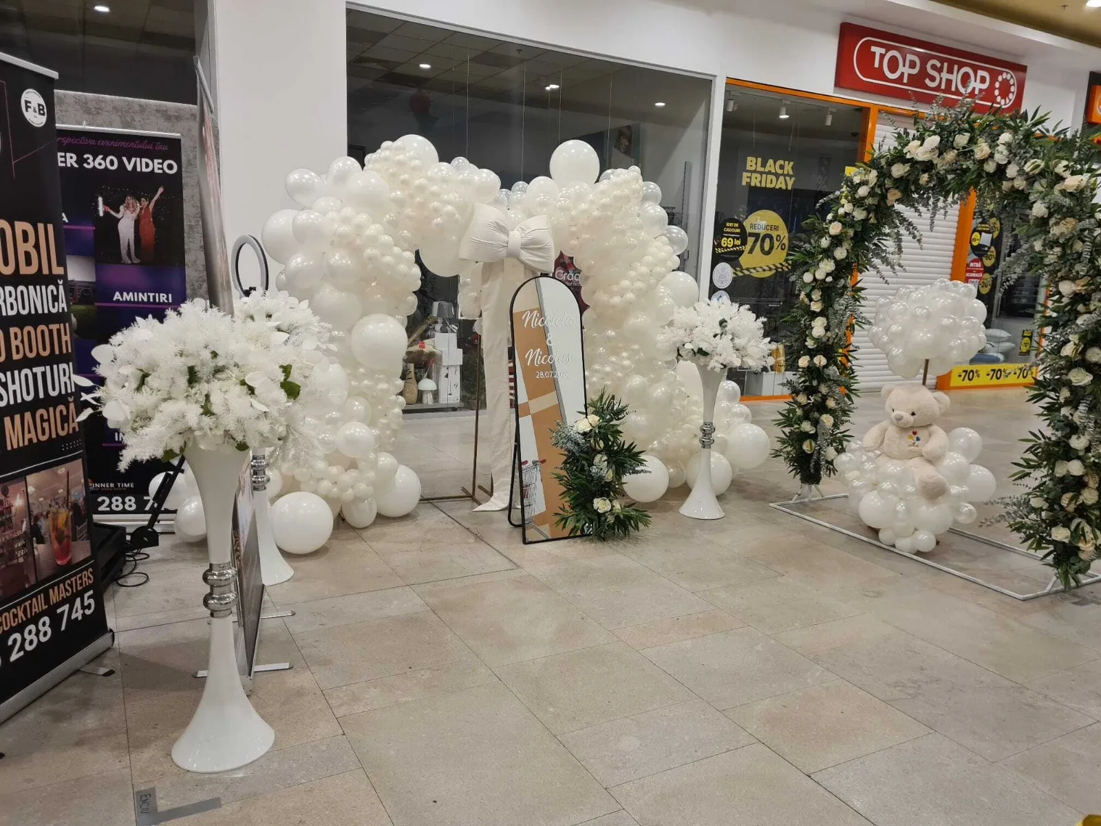Vedere generala a standului SimoEvents cu arcada de baloane albe si oglinda la targul de nunti