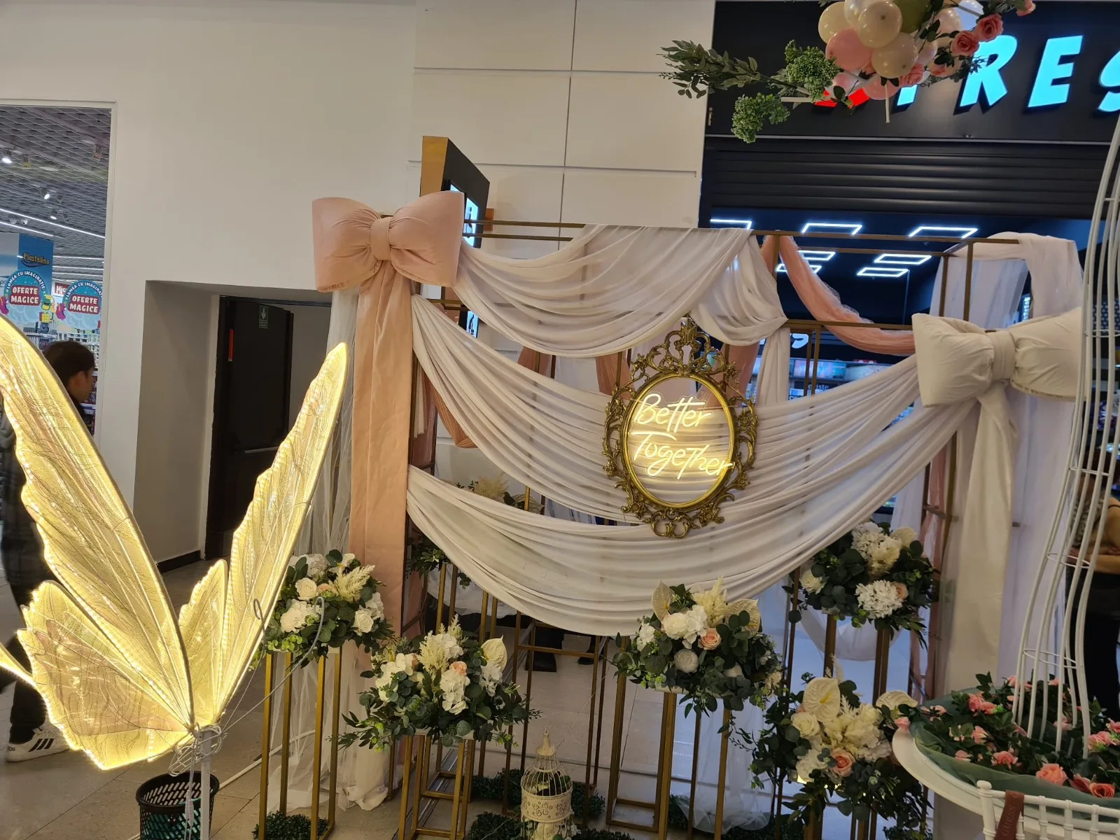 Aripi de fluture luminoase langa arcada roz cu fundita si oglinda aurie